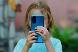 Ein kleines Mädchen, das ein Foto mit ihrem Handy macht.