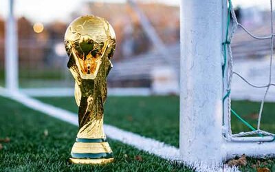 Eine goldene Fußballtrophäe steht neben einem weißen Fußballtor.
