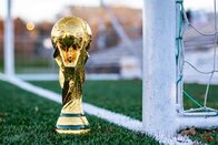 Eine goldene Fußballtrophäe auf einem Fußballfeld; Bild: My Profit Tutor auf Unsplash Eine goldene Fußballtrophäe steht neben einem weißen Fußballtor.