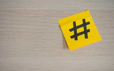Ein gelbes Blatt Papier mit einem Raute-Symbol darauf; Bild: Walls.io auf Unsplash