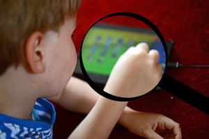 Kind vor Tablet und Lupe; Bild: Internet-ABC