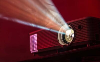 Bild von einem Beamer, der in der Dunkelheit stahlt.