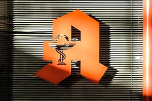 Schwarz-rote Holztür; Bild: Mika Baumeister auf Unsplash Apothekenschild mit "A" auf einem Fenser.