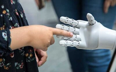 Eine Person, die eine Roboterhand vor einem Spiegel hält; Bild: Katja Anokhina auf Unsplash