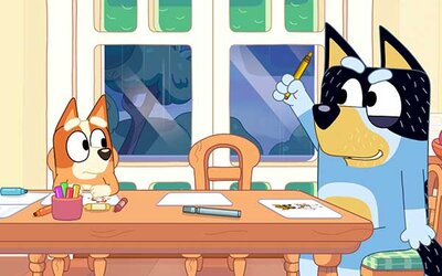 Welpe Bingo und Papa Bandit sitzen am Essttisch im Spiel "Bluey's Quest for the Gold Pen"; Bild: PM Studios Welpe Bingo und Papa Bandit sitzen am Essttisch.