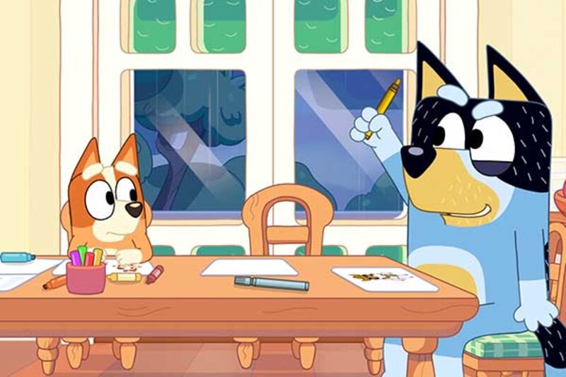 Welpe Bingo und Papa Bandit sitzen am Essttisch im Spiel "Bluey's Quest for the Gold Pen"; Bild: PM Studios Welpe Bingo und Papa Bandit sitzen am Essttisch.