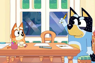 Welpe Bingo und Papa Bandit sitzen am Essttisch im Spiel "Bluey's Quest for the Gold Pen"; Bild: PM Studios Welpe Bingo und Papa Bandit sitzen am Essttisch im Spiel "Bluey's Quest for the Gold Pen"; Bild: PM Studios