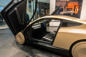 Ein Auto mit offener Tür in einem Museum ausgestellt; Bild: Maxim auf Unsplash